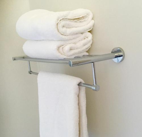a towel rack with white towels on it at Stay Kerikeri in Kerikeri