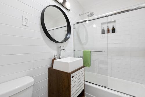 une salle de bain blanche avec un lavabo et un miroir dans l'établissement Rancho Relaxo - hot tub, fire pit, open air bath and comfy beds, à Twentynine Palms