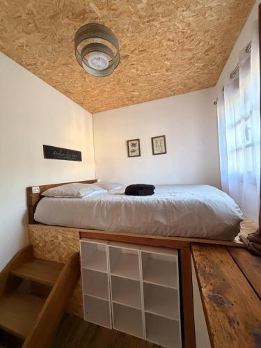 a bedroom with a bed and a ceiling at L'atelier in Festigny