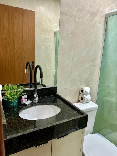a bathroom with a sink and a toilet at Sanzé Flats - São José da C Grande in São José da Coroa Grande