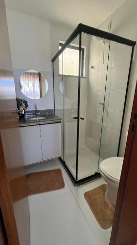 a bathroom with a glass shower and a toilet at Seu Descanso a Beira Mar in Ilhéus