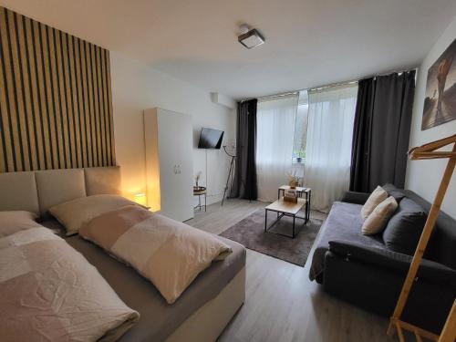ein Schlafzimmer mit einem Bett und einer Couch in der Unterkunft Stilvolle Wohnung in Wuppertal inkl. Kaffee & Tee in Wuppertal
