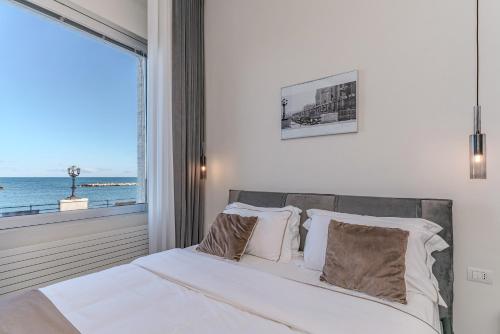 a bedroom with a bed with a view of the ocean at Alta Marea Apulia sea view in Bari