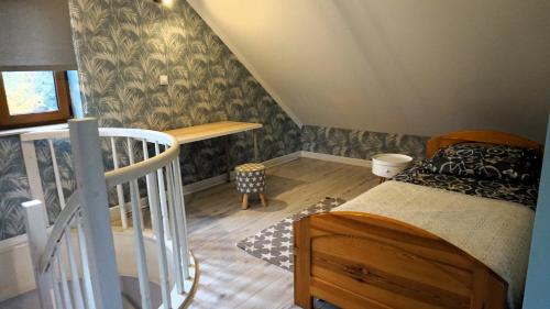 Cette petite chambre comprend un lit et un escalier. dans l'établissement Domki nad jeziorem Ostoja Głuszyńska, à Potołówek