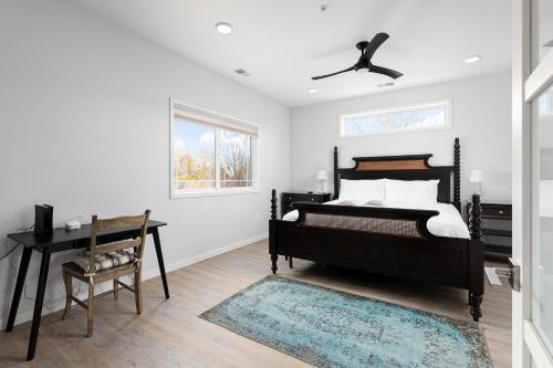 a bedroom with a bed and a desk and a window at Slabtown Penthouse - Modern Condo - Private Rooftop Deck 