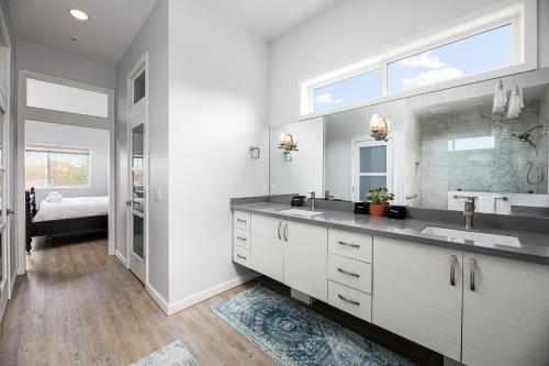 a bathroom with a sink and a large mirror at Slabtown Penthouse - Modern Condo - Private Rooftop Deck 