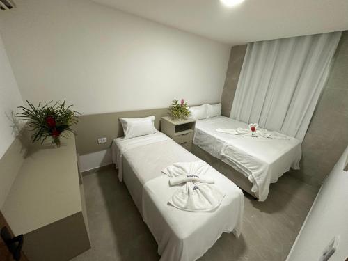 una camera d'albergo con due letti in una stanza di Sanzé Flats - São José da C Grande a São José da Coroa Grande