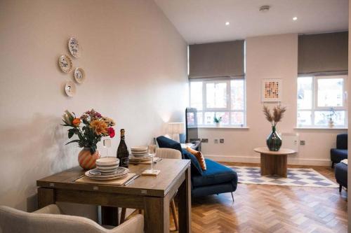 un salon avec une table et un canapé bleu dans l'établissement Ripon City Centre - 1 Bedroom flat - free parking, à Ripon