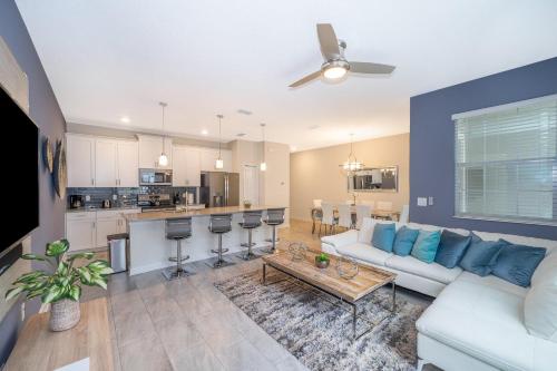 a living room with a white couch and a kitchen at 4964RS TOWNHOUSE 4 BEDROOMS & 3 BATHROOMS + POOL in Kissimmee