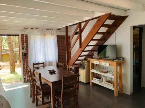 a dining room with a table and a staircase at Nuevos Aires in Mar de las Pampas