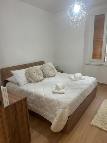 a bedroom with a bed with white sheets and a chandelier at Casa Orchidea in Genova