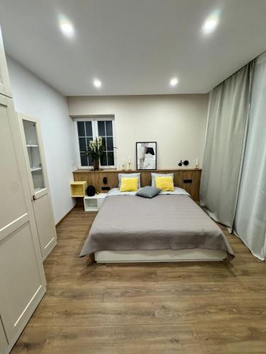 a bedroom with a large bed with yellow pillows at Danubia-residence in Komárno