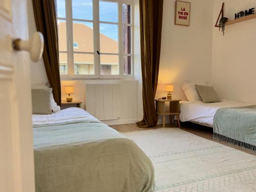 une chambre avec deux lits et une fenêtre dans l'établissement Venez Chez Vous Parenthese du lac, à Lathuile