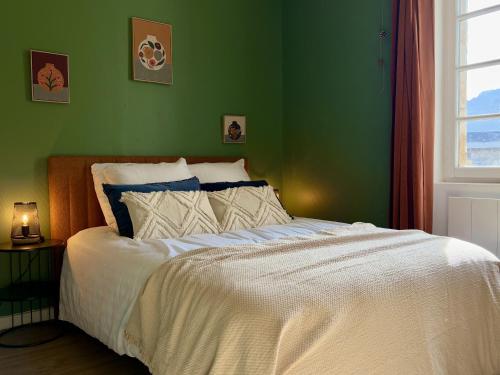 une chambre avec un lit blanc avec un mur vert dans l'établissement Venez Chez Vous Parenthese du lac, à Lathuile