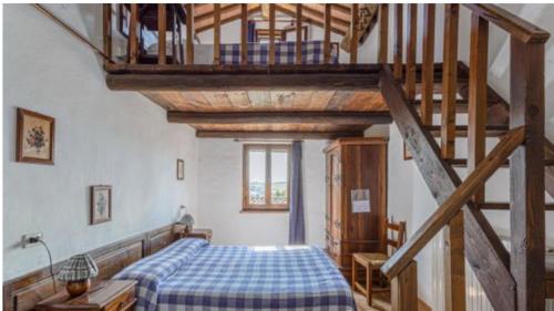 ein Schlafzimmer mit einem Bett und einer Holztreppe in der Unterkunft Agritur Villa Osvaldo Castiglione del Lago Perugia Piscina acqua salata possibilità colazione in Castiglione del Lago