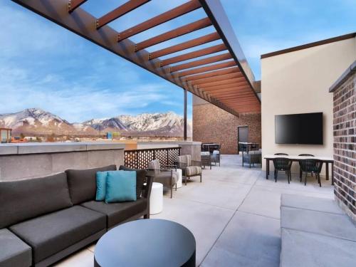 eine Terrasse mit einem Sofa und einem Flachbild-TV in der Unterkunft Cozy Studio in Brickyard shopping district! in Salt Lake City