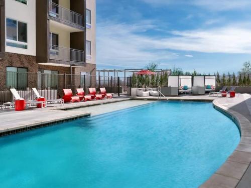 ein Swimmingpool mit Stühlen und einem Gebäude in der Unterkunft Cozy Studio in Brickyard shopping district! in Salt Lake City