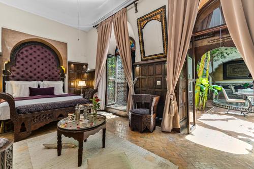 1 dormitorio con cama extragrande y mesa en Riad ILayka, en Marrakech