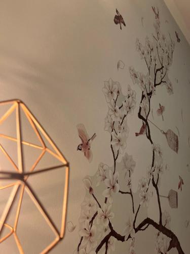 a wall mural of a tree with butterflies and birds at Canto do Florescer in Pesqueira