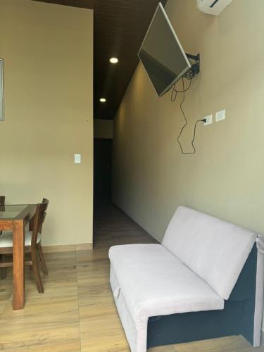 a living room with a white couch and a tv at Mar Adentro Casa 13 in Santa Cruz de la Sierra