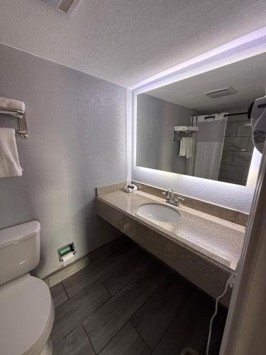 a bathroom with a sink and a mirror at Executive Inn & Kitchenette Suites-Eagle Pass in Eagle Pass