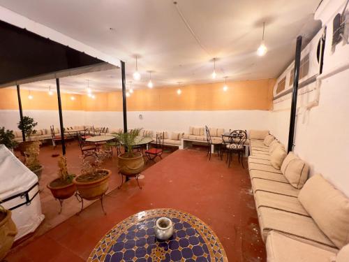 ein Wohnzimmer mit einer Couch sowie Tischen und Stühlen in der Unterkunft Riad Alma fes in Fès