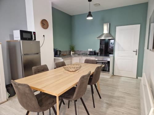 a kitchen with a dining room table and chairs at Les appartements de Lucie in Eaux-Bonnes