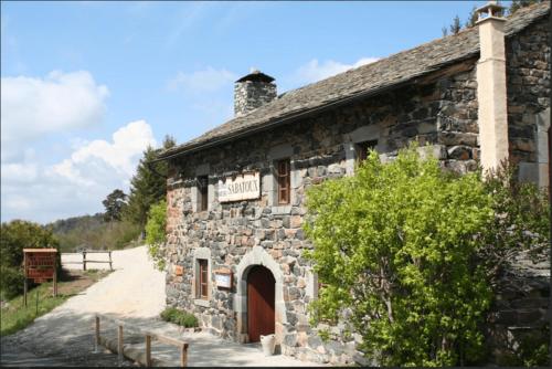 un viejo edificio de piedra en un camino de tierra en Auberge & Camping Sabatoux, en Montusclat