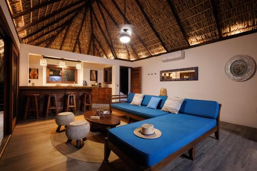 a living room with a blue couch and a bar at Casa Kalmar in Zipolite