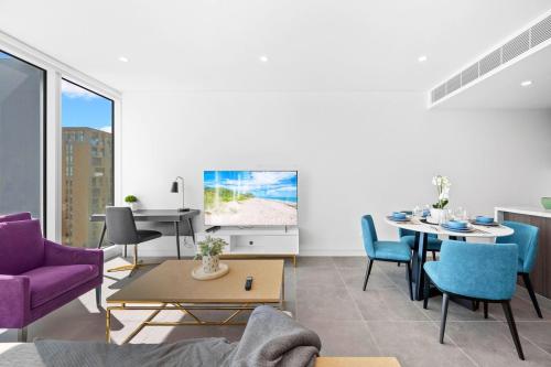a living room with a table and a tv at SOP06 Stylish and Cosy 2 Bedroom Apt in Sydney