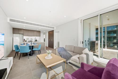 a living room with a couch and a table at SOP06 Stylish and Cosy 2 Bedroom Apt in Sydney