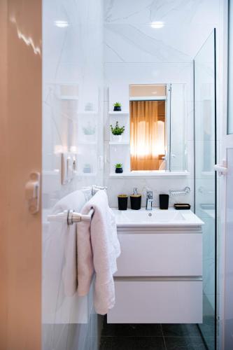 a white bathroom with a sink and a mirror at Dar Belleza in Tangier