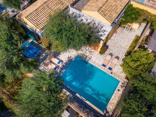 an overhead view of a swimming pool with chairs and trees at Barbati Beach - Villa Ithika in Barbati