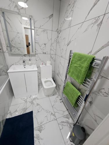 a bathroom with a toilet and a green towel at Union House in Stratford-upon-Avon