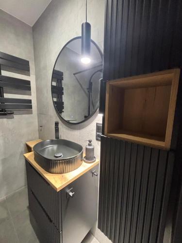 a bathroom with a sink and a mirror at Loft Re Design Apartament in Głogów