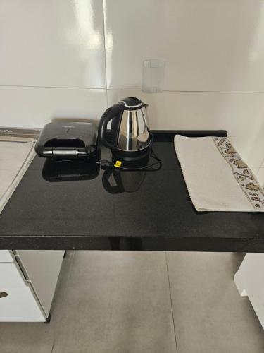 a tea kettle is sitting on a black table at Apto Bell Valle I in Sorriso