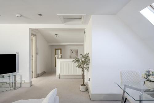 a living room with white walls and a tv at Moulsham Apartments in Chelmsford - Apartment C, Apartment E - Free WiFi & Free Parking - Long Stays Welcome in Chelmsford