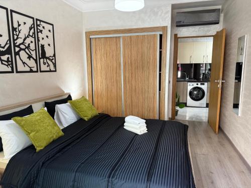 a bedroom with a large bed with green pillows at Studio Stadium morocco for family in Mohammedia