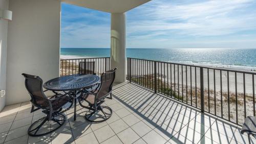 a balcony with a table and chairs and the ocean at The Oasis 405 formerly Phoenix West II 405 condo in Romar Beach