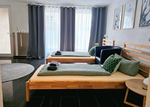 ein Zimmer mit zwei Betten und einem Stuhl in der Unterkunft Gästeappartement Viktoria in Sinsheim