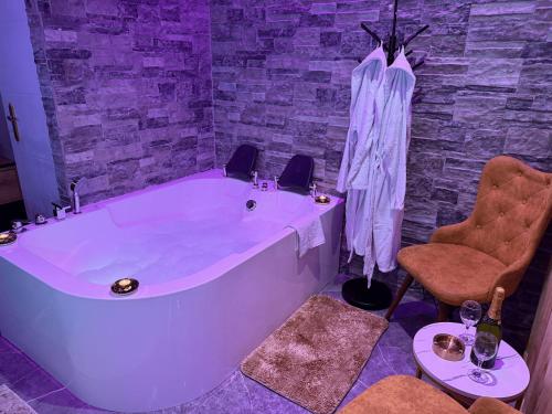 a large white tub in a room with a stone wall at Dubai Spa Apartments in Novi Sad