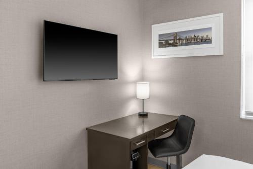 a desk with a lamp and a television on a wall at Solita Soho Hotel in New York