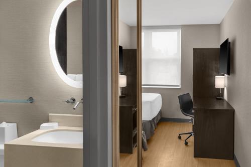 une salle de bain avec un lavabo et un miroir dans l'établissement Solita Soho Hotel, à New York