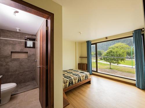 a bathroom with a bed and a shower and a window at The Traveler Hostel in Otavalo