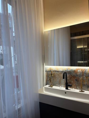 ein Badezimmer mit Waschbecken und Spiegel in der Unterkunft Border Bliss - Private Room with Bathroom in a Cozy Home in Kerkrade