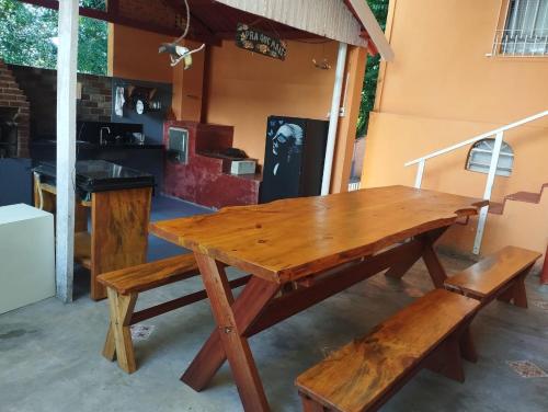 a wooden table and two benches in a kitchen at Recanto Verde in Conceição dos Ouros
