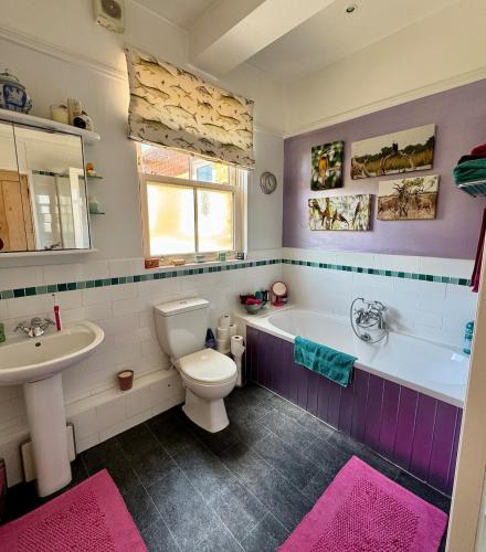 a bathroom with a toilet and a tub and a sink at Spacious Edwardian home in Stroud