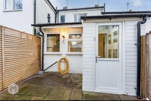 a house with a white door and a fence at Entire luxury home in Manchester in Bury