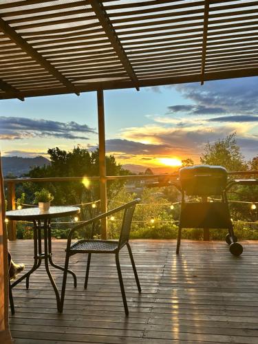 une table et des chaises sur une terrasse avec un coucher de soleil dans l'établissement Alto Paraíso Glamping "B", à Carmen de Viboral