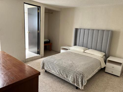 a bedroom with a large bed and a mirror at Depto de Descanso Económico vuelos AICM, conciertos GNP, F1 in Mexico City